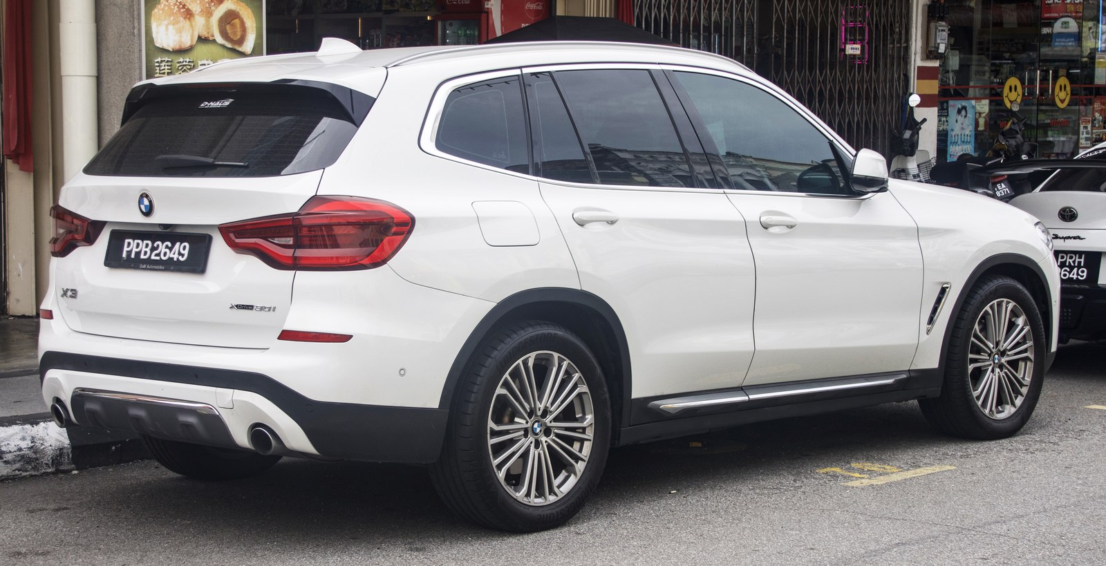 White BMW X3 SUV showing the roof-mounted shark-fin antenna at the rear